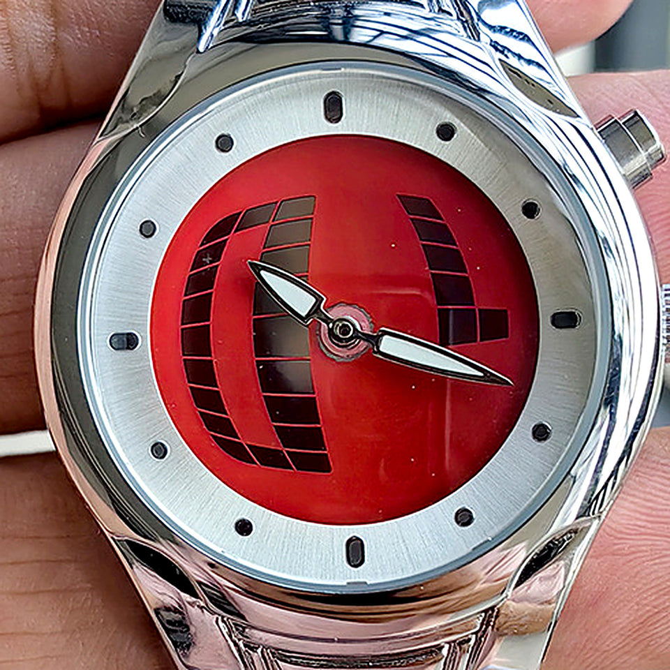 Gros plan sur le cadran rouge de la TIMELOOM 02 Rond : grille 3D sombre, index ronds et aiguilles feuille